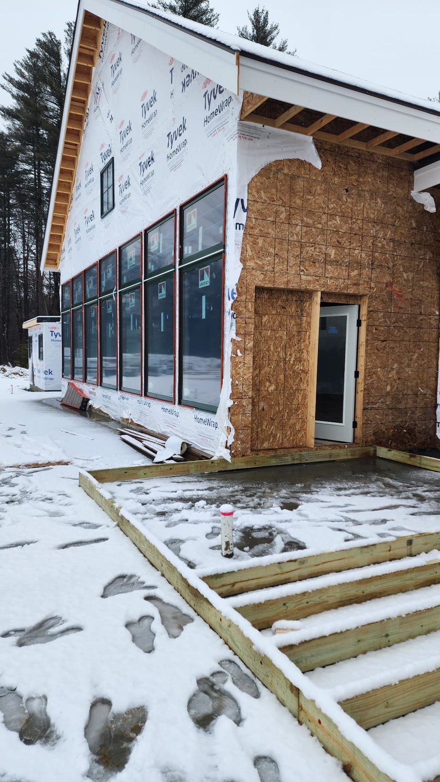 Home addition under construction with weather-tight envelope and new windows