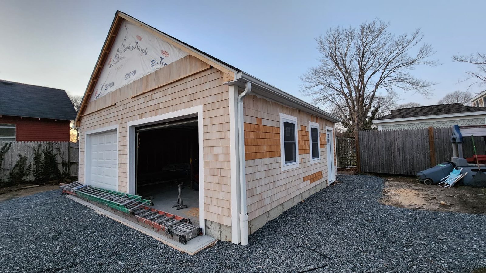Garage clad in cedar shingle siding with new gutters installed