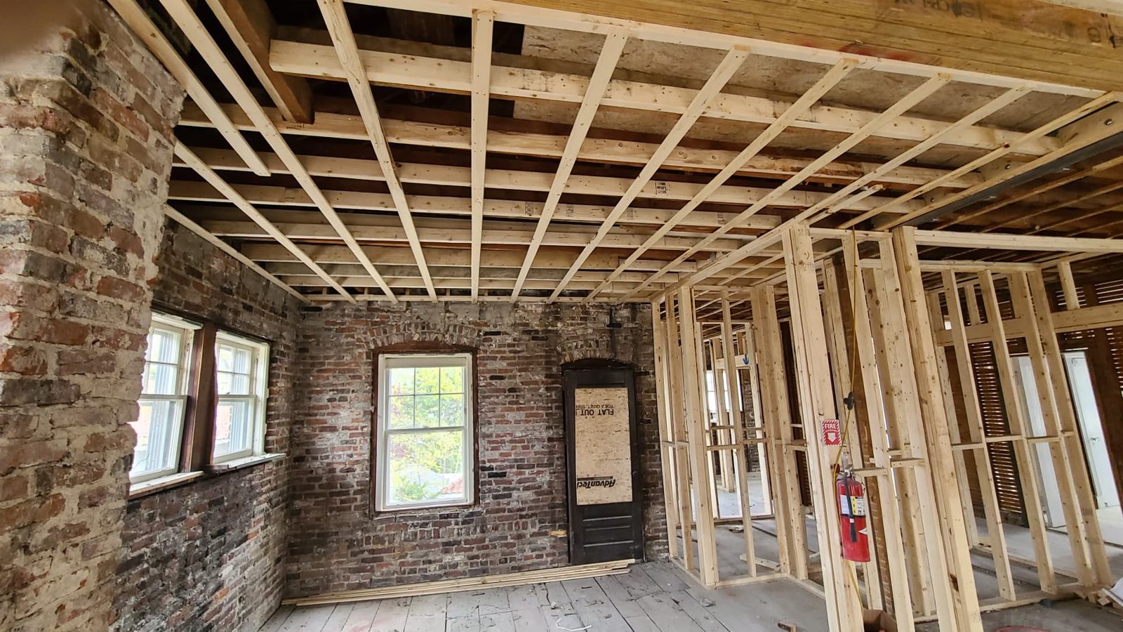 Interior renovation with exposed brick and new ceiling framing